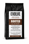 A 12 oz black bag of Evolve Bean Coffee Company's Rooted All-Day Blend medium-dark roast coffee, shown against a plain white background.
