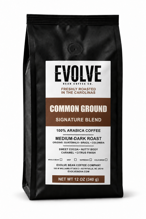  12 oz black bag of Evolve Bean Coffee Company Common Ground Signature Blend medium-dark roast coffee on a white background.