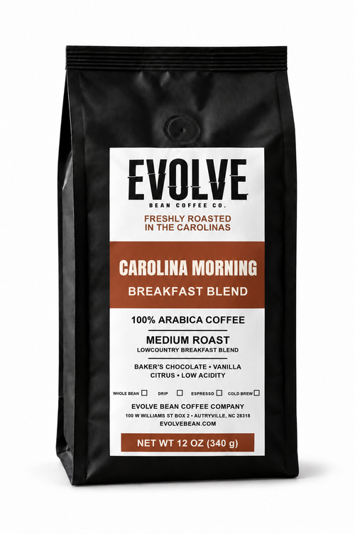 A 12 oz black bag of Evolve Bean Coffee Co. Carolina Morning Blend medium roast coffee, featuring a white and brown label on a clean white background.
