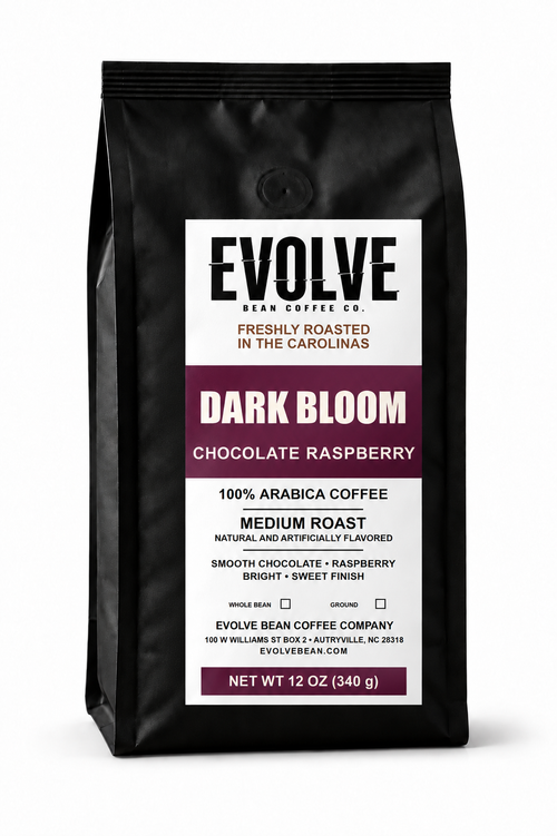A 12 oz bag of Evolve Bean Coffee Company Dark Bloom Chocolate Raspberry coffee, in a matte black bag with a white and dark purple label.